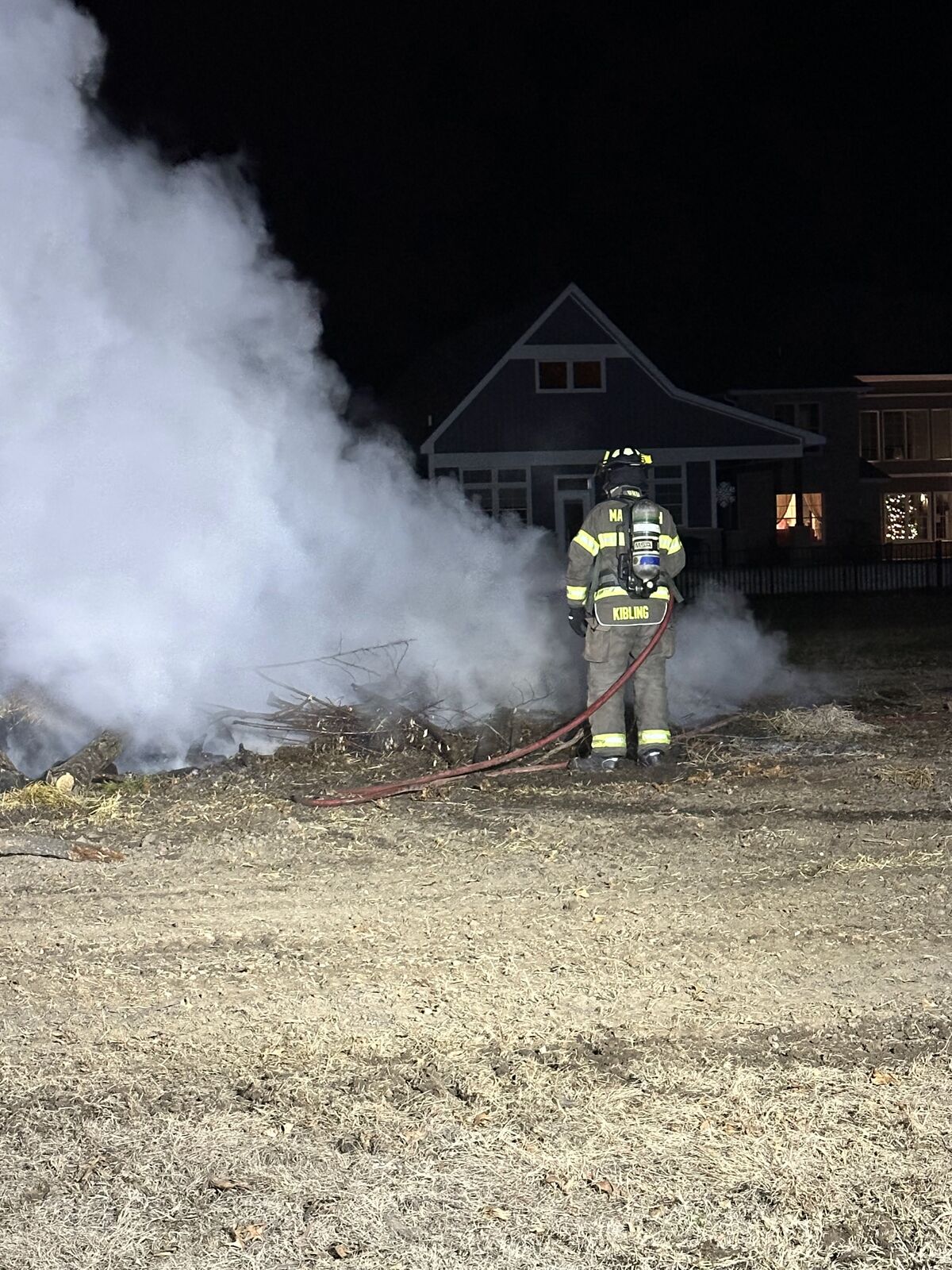 Firefighter Kibling extinguishing a brush fire at night